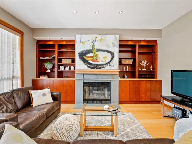 Living area with recessed lighting, built in shelves, a fireplace, and wood finished floors
