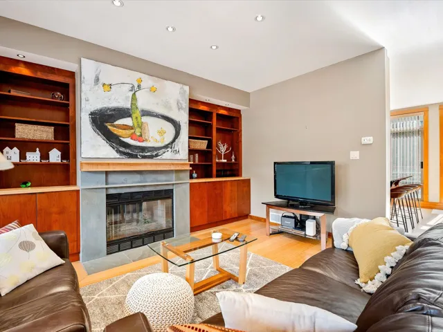 Living area featuring built in features, a fireplace with flush hearth, wood finished floors, and recessed lighting