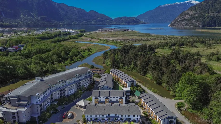 Birds eye view of property with a view of trees and a water and mountain view