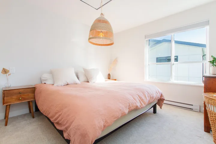Bedroom featuring carpet flooring, a baseboard heating unit, and multiple windows