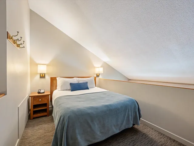 Carpeted bedroom featuring a textured ceiling and vaulted ceiling