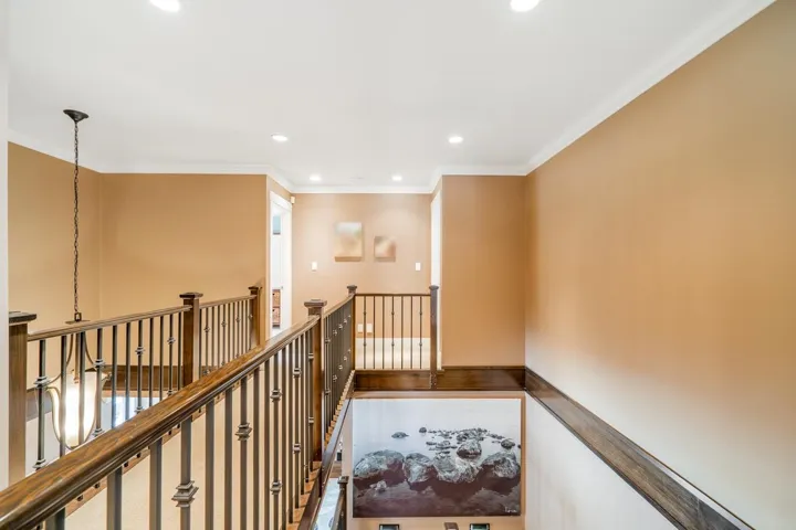 Corridor with ornamental molding, an upstairs landing, and recessed lighting