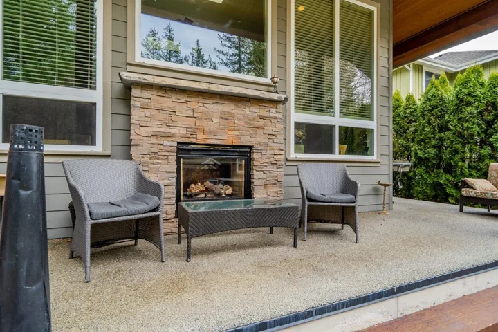 View of patio with an outdoor stone fireplace