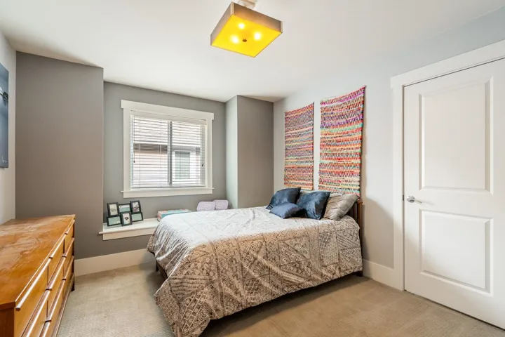 Bedroom with light colored carpet and baseboards