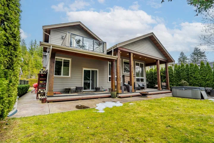 Rear view of house featuring a hot tub, a patio area, and a wooden deck