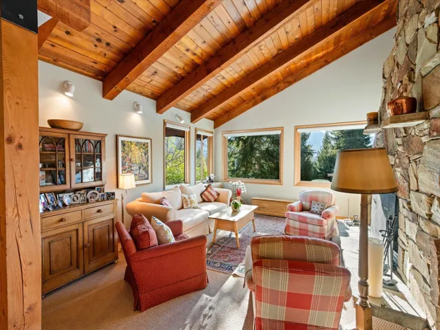 Living area featuring carpet, a wood ceiling with exposed beams, and high vaulted ceiling
