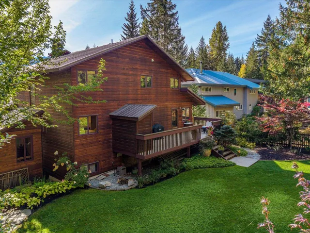 Rear view of property with a lawn and a deck
