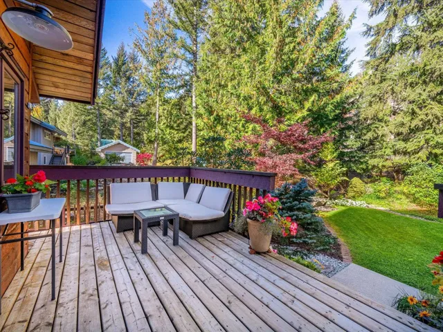 Deck with outdoor lounge area, a lawn, and view of scattered trees