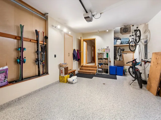 Garage featuring a heating unit, a garage door opener, and electric panel
