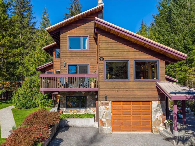 View of front of home with stone siding and a garage