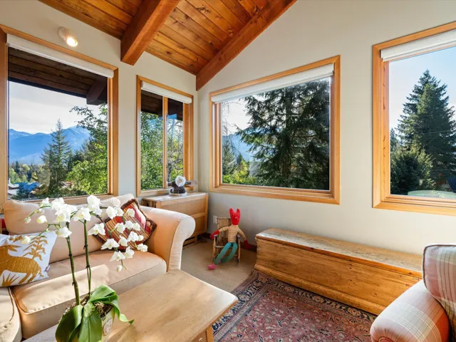 Sunroom / solarium with carpet flooring, wooden ceiling, and a mountain view