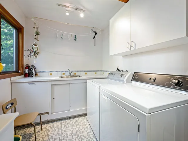 Washroom featuring cabinet space and washing machine and dryer