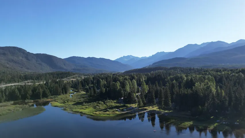 View of mountain backdrop with a heavily wooded area and a large body of water