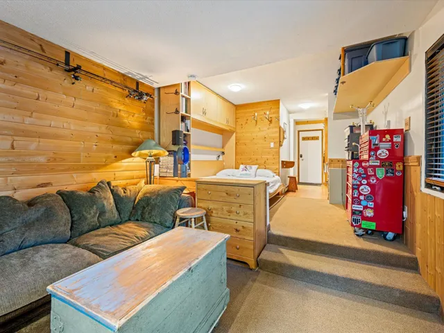 Bedroom featuring wooden walls and carpet floors