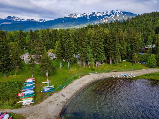 Drone / aerial view of a heavily wooded area and a water and mountain view