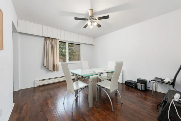 Dining space featuring a baseboard heating unit, a ceiling fan, and wood finished floors