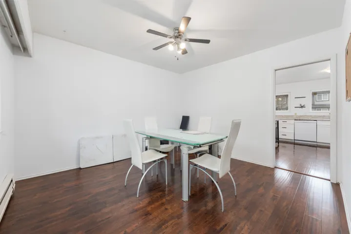 Dining room with baseboard heating, baseboards, ceiling fan, and hardwood / wood-style floors