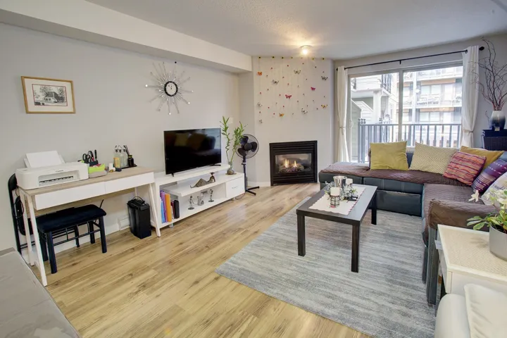 Living room featuring a glass covered fireplace and light wood-type flooring