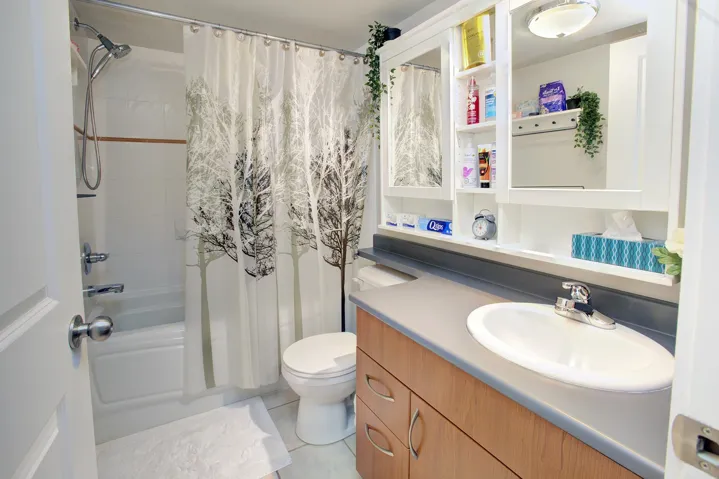 Bathroom with vanity, shower / tub combo with curtain, and light tile patterned flooring