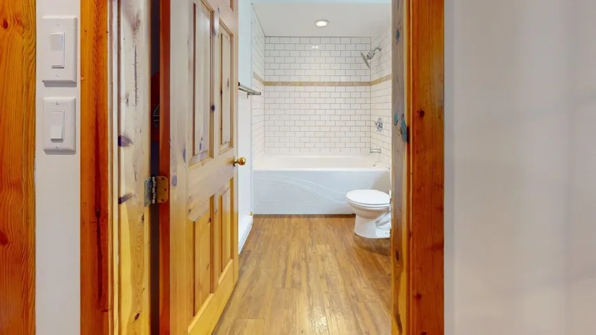 Bathroom featuring light wood-style floors and  shower combination