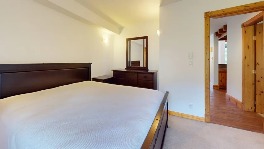 Bedroom with baseboards and light colored carpet