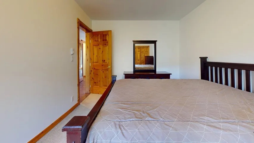Bedroom featuring light carpet and baseboards