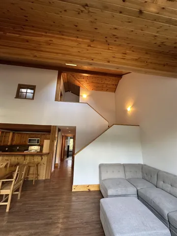 Living room with wood ceiling, dark wood-style flooring, and high vaulted ceiling