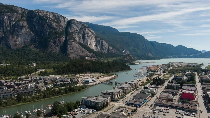 Aerial perspective showcasing a vibrant coastal community nestled against imposing mountains