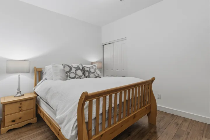 Bedroom featuring wood-finish flooring, white baseboards, and a neutral wall color