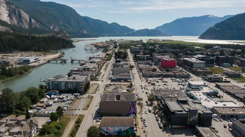 Aerial perspective of a waterfront community framed by mountainous terrain