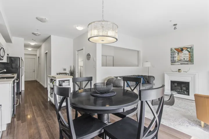 Open-concept living space with dark wood-finish flooring, a contemporary chandelier, a built-in fireplace, and recessed lighting