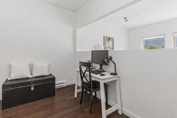 Dedicated workspace featuring rich wood-finish flooring and a partial wall separation