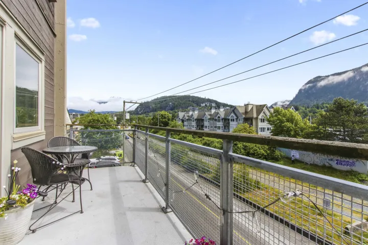 Balcony with metal railing and views of distant mountains