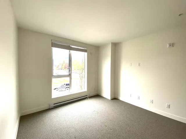 Carpeted empty room featuring a baseboard radiator and baseboards