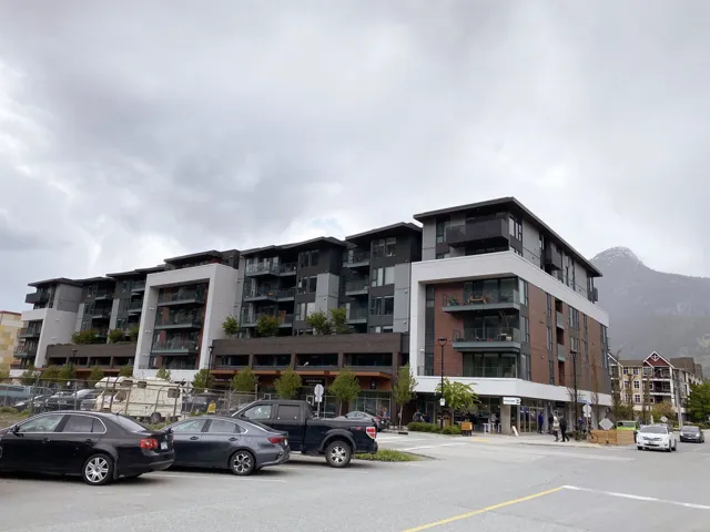 View of apartment building / complex featuring a mountain view and uncovered parking