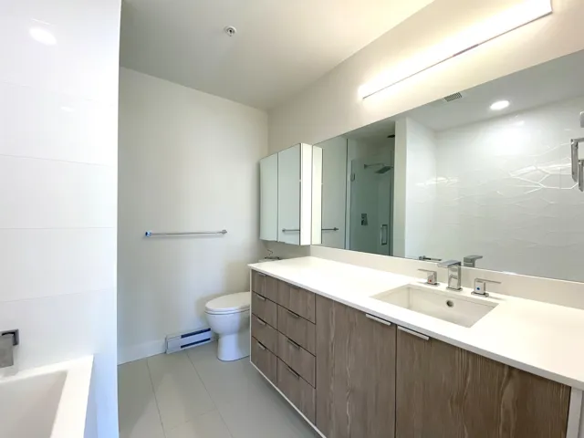 Full bathroom featuring baseboard heating, a shower, vanity, tile patterned floors, and a tub to relax in