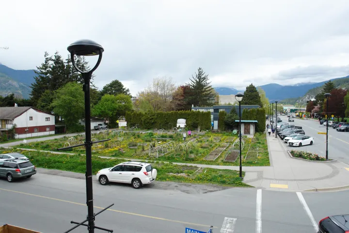View of asphalt road featuring a mountain view, street lighting, and sidewalks