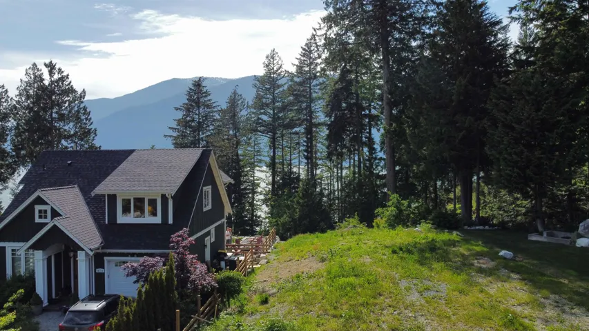 View of home's exterior with a mountain view, an attached garage, and a shingled roof