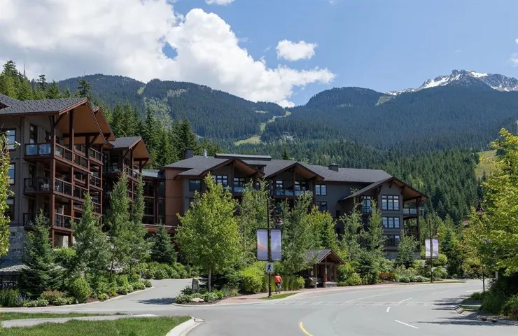 Contemporary multi-story buildings featuring expansive balconies, dark siding, and multiple windows