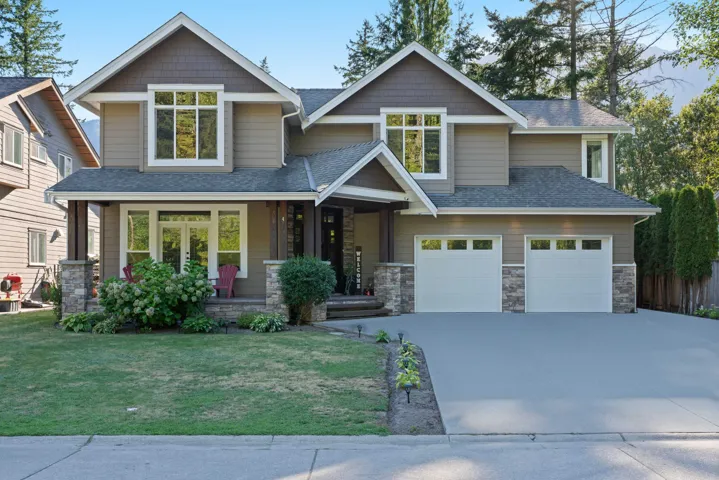 Craftsman-style house with a porch, concrete driveway, a front yard, and stone siding