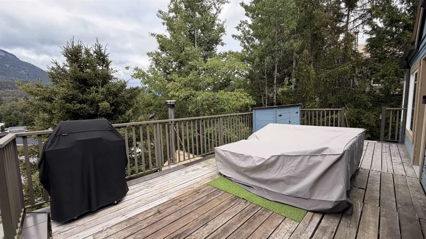 Expansive wood-plank deck featuring a wood railing and a mountain backdrop