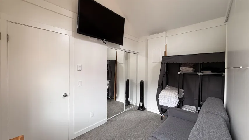 Compact interior space featuring white walls and a carpeted floor