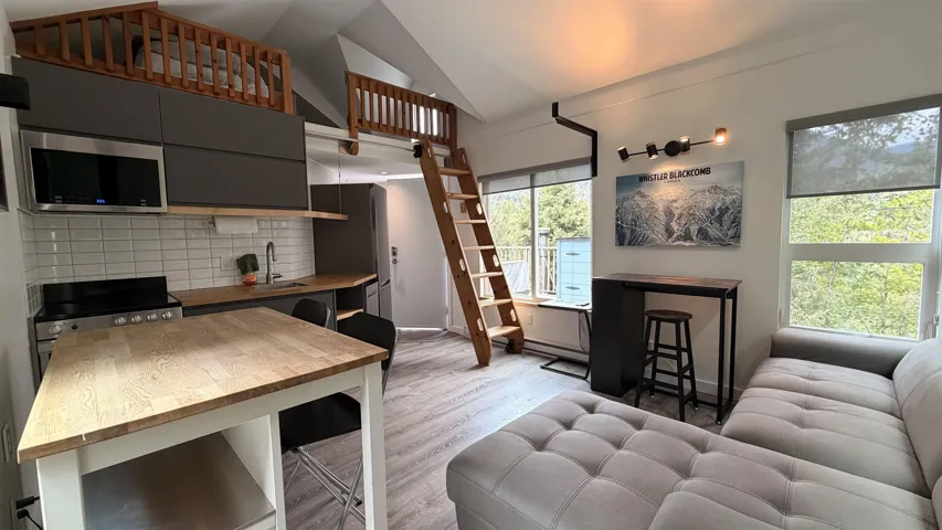 Open-concept living area with integrated kitchen and lofted spaces