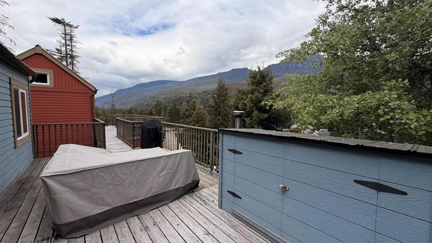 Expansive outdoor decking with a wood finish, featuring a surrounding railing, and distant mountain scenery
