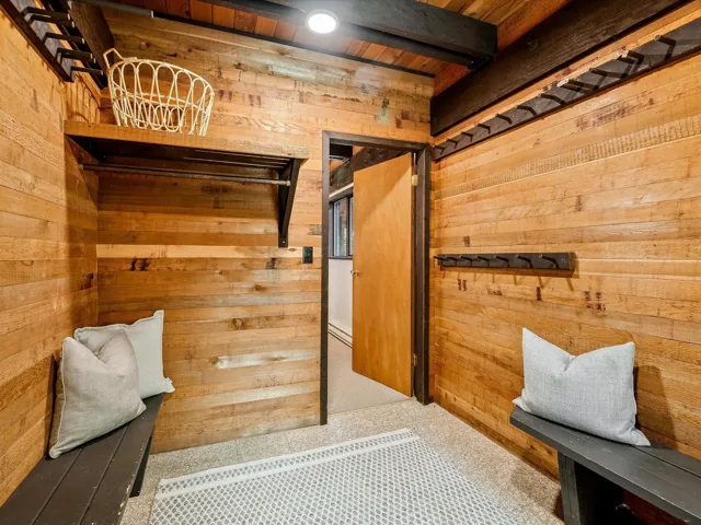 Mudroom featuring wooden walls and beam ceiling