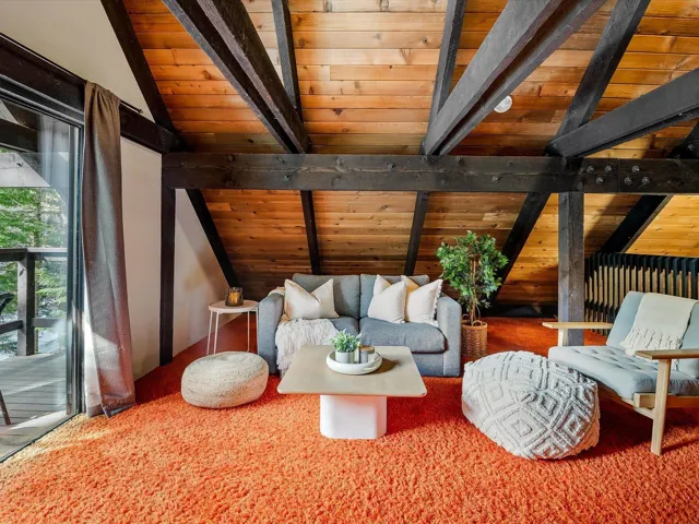 Living area featuring wood ceiling and lofted ceiling with beams