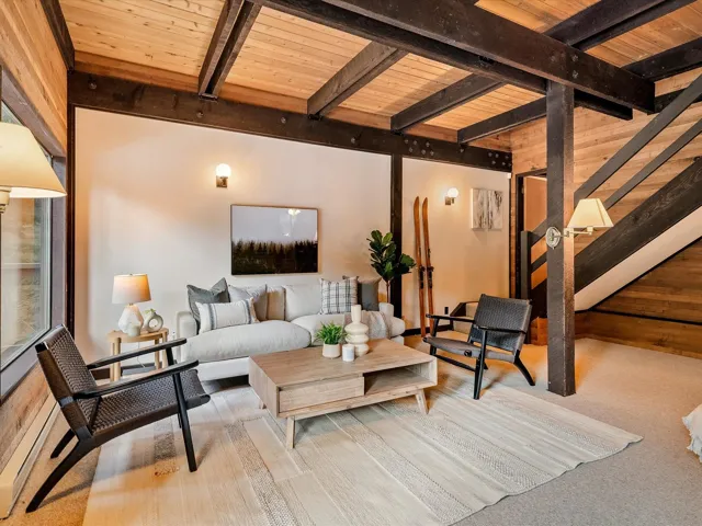 Living room featuring wood walls, wood ceiling, and beam ceiling