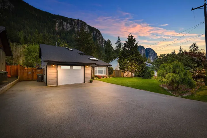 View of front of home featuring driveway, a gate, and an attached garage