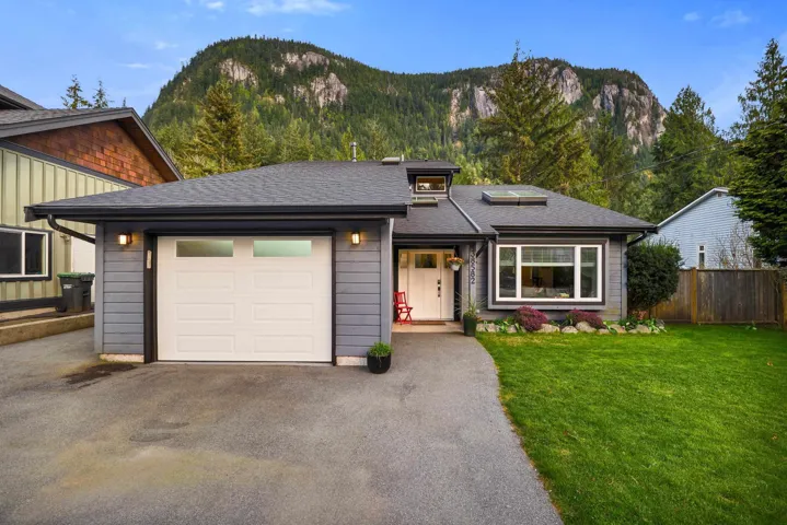 View of front of house with an attached garage, asphalt driveway, a mountain view, and roof with shingles