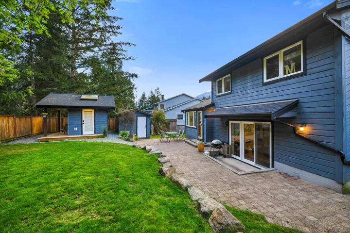 Back of property with a storage shed, a patio area, and a fenced backyard
